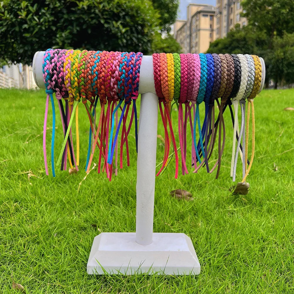 colourful mosquito repellent wristbands displayed on a white stand outdoors with grass and buildings in background