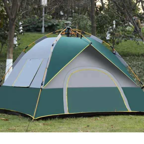 Rear view of forest green 2-3 person pop-up dome tent with yellow trim, waterproof shell and ventilation panels pitched on grass in Spain