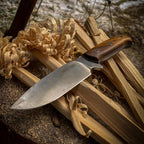 JEO-TEC No.1 fixed blade knife resting on leather sheath in outdoor camp setting
